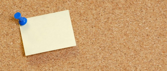 cork board with blank note attached with thumb pin..