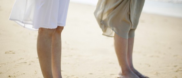 Two Women Standing Side by Side on Sandy Beach
