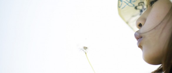 Woman Blowing a Dandelion